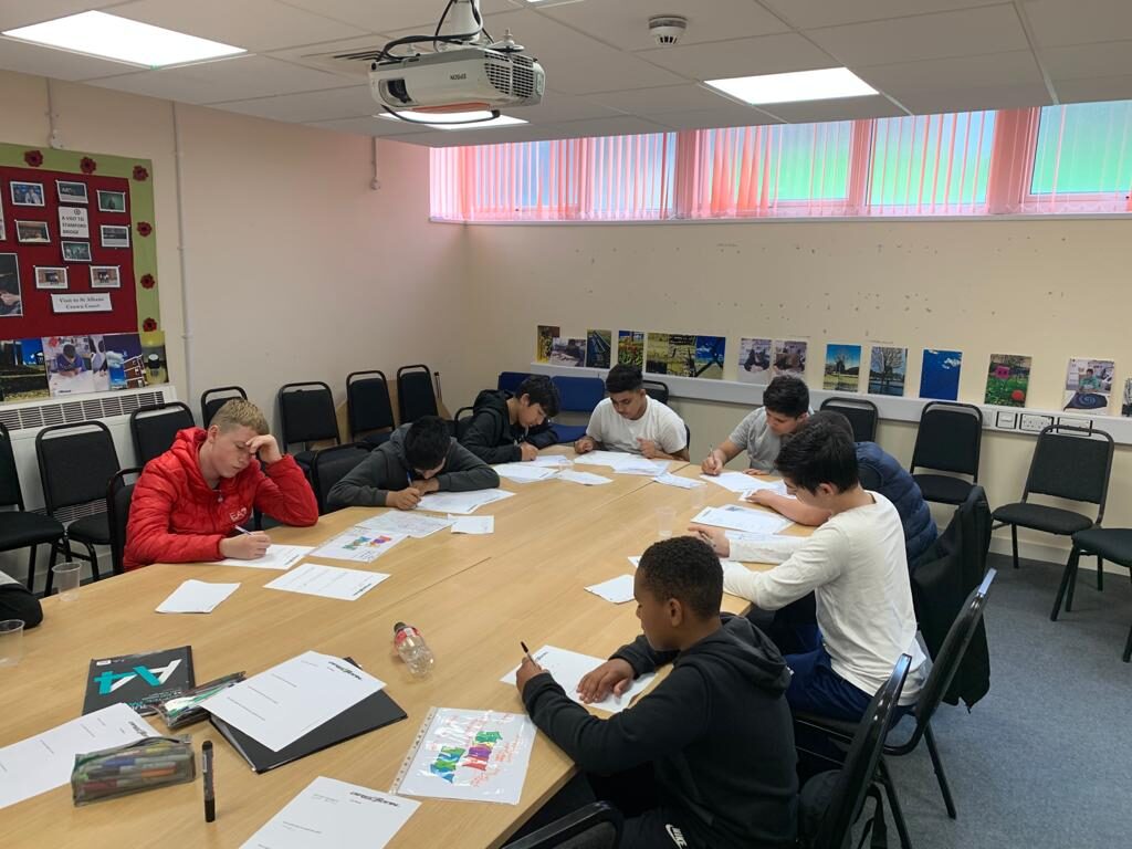 A small group working through activities around a table with a Directional staff member