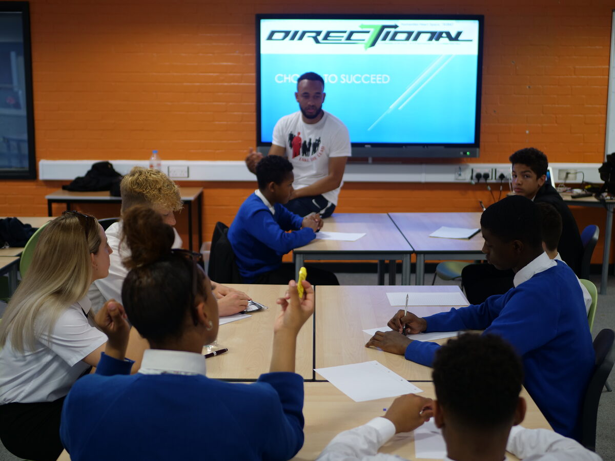Pupils working at tables during a Directional group session, with a facilitator at the front of the room